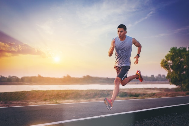道路に全力疾走を走っている人のシルエット 屋外トレーニング中にフィットする男性フィットネスランナー プレミアム写真