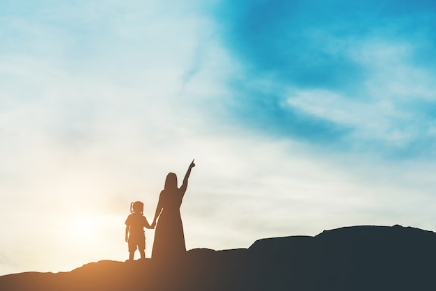Silhouette of mother with her daughter standing and sunset Free Photo Silhouette of mother with her daughter standing and sunset Free Photo