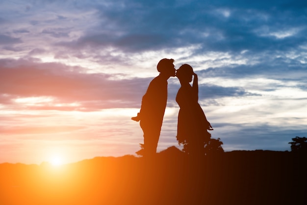無料の写真 夕日の背景の上にキス甘いカップルのシルエット