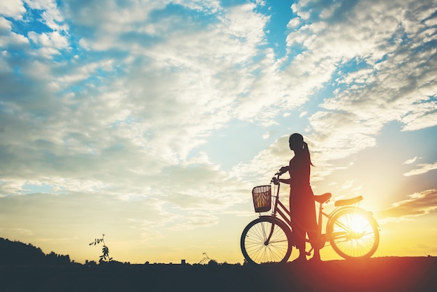 Silhouette of women with bicycle and beautiful sky Free Photo