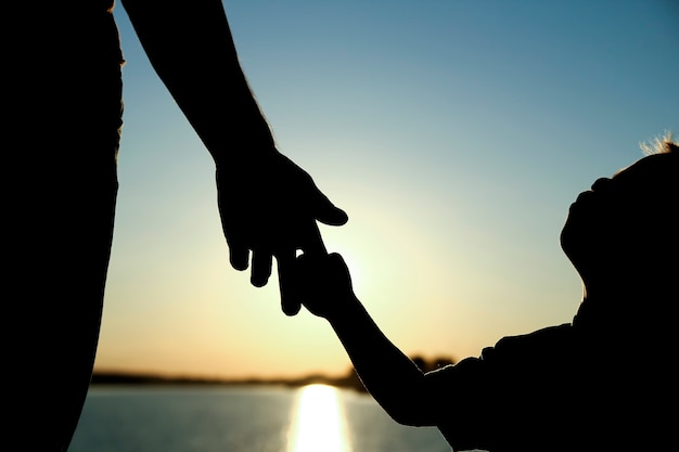 Premium Photo Silhouette The Parent Holds The Hand Of A Small Child