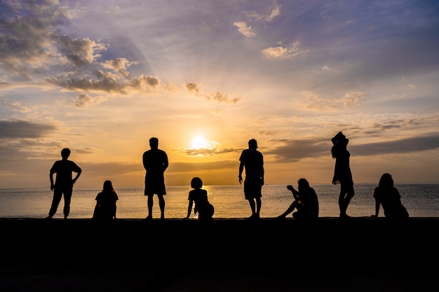 Premium Photo | Silhouette of people relaxing watching colorful sunrise ...