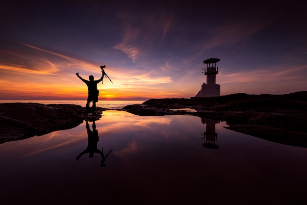 Silhouette photographer with lighthouse Premium Photo