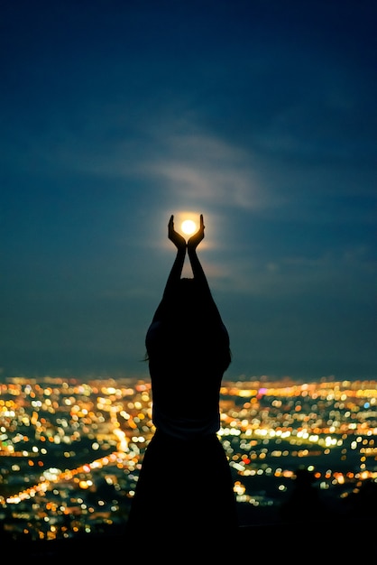 Silhouette woman portrait with full moon in city night light bokeh background Photo | Premium ...