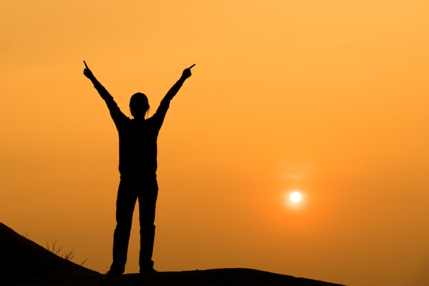 Premium Photo | Silhouette of woman spreading hand to the sky