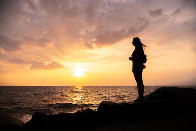 Silhouette woman standing, sunset sky over horizon. | Premium Photo