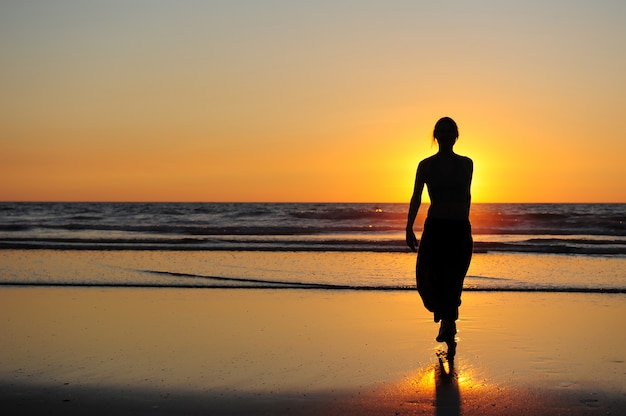 Premium Photo Silhouette Of Young Woman Against Sunset By The Sea Figure Of A Woman In The Rays Of Setting Sun Beautiful Sunset Touchdown And A Girl Walking On Seashore