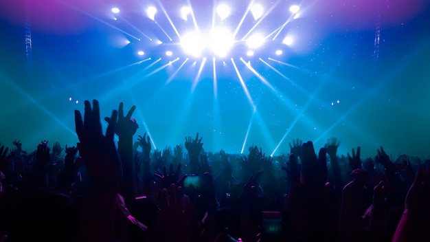 Premium Photo | Silhouettes of raised hands at a music concert or festival