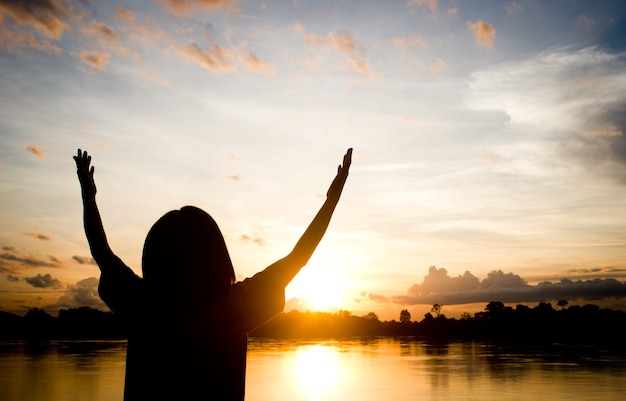 Premium Photo | Silhouettes women praying hand over beautiful sun set ...