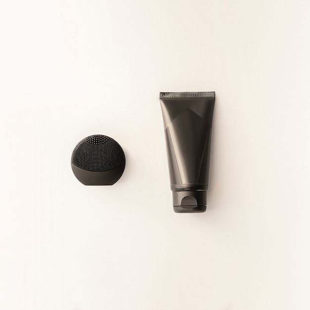 Silicone black face brush and cream black tube isolated. mockup for male accessories.beauty blog concept.men cosmetics flat lay for branding. set of black personal hygiene products Premium Photo