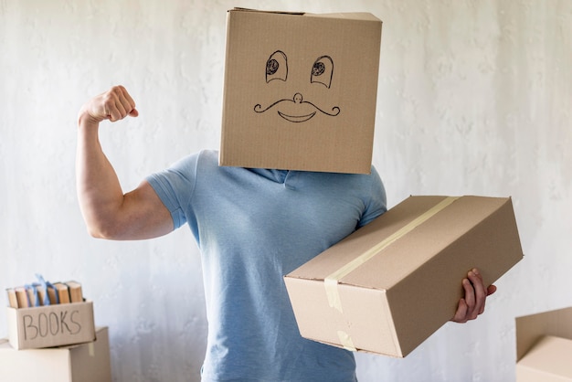 Free Photo | Silly man with box over head showing bicep on moving day