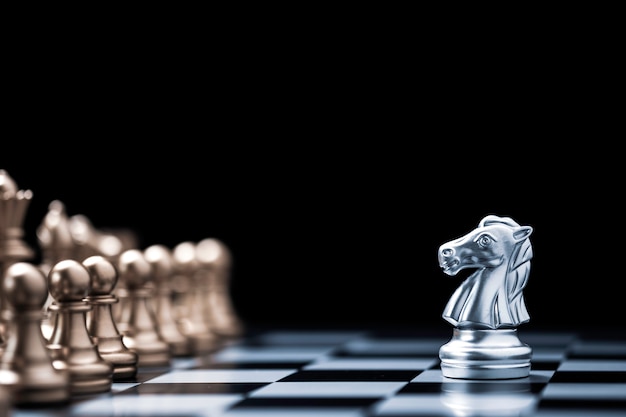 銀の馬のチェスは チェス盤で金のチェスの敵と遭遇します プレミアム写真