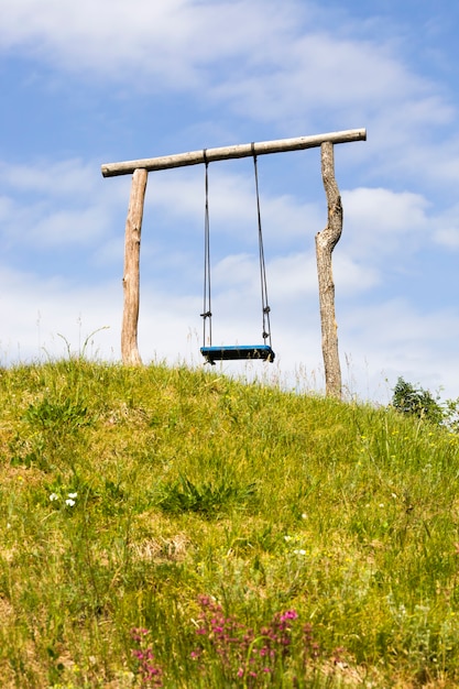 Premium Photo | Simple primitive wooden swing set on a hill, summer ...