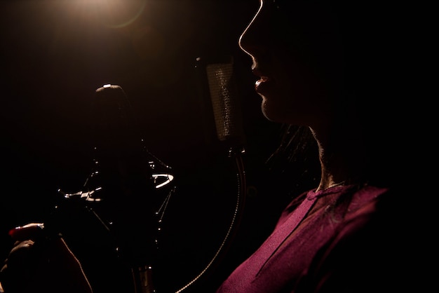 Premium Photo | Singer recording a song in music studio.