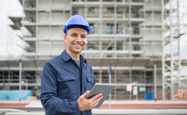 Premium Photo | Site manager using his tablet in front of a ...