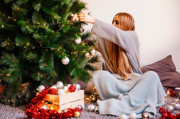 Free Photo | Sitting woman decorating christmas tree