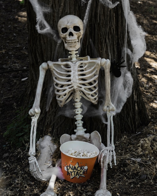 skeleton-sitting-near-tree-with-popcorn_23-2147905068.jpg