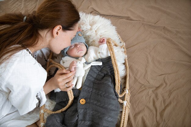 Premium Photo Sleepy Baby In A Wicker Cradle In Warmth Near A Happy