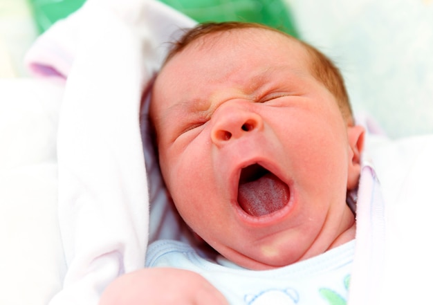 彼の口を開いてあくび眠そうな生まれたばかりの赤ちゃん プレミアム写真