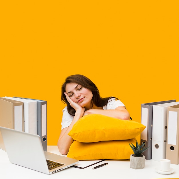 Sleepy Woman With Pillows On Her Desk Free Photo