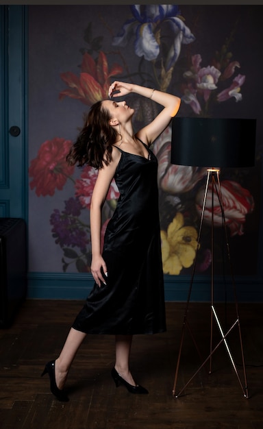 Premium Photo | Slender brunette woman in black silk dress posing in a ...
