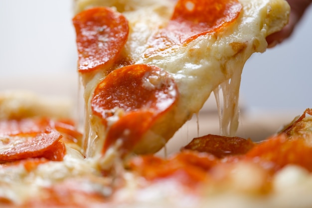 Slice of hot pizza cheese spreading closeup Premium Photo