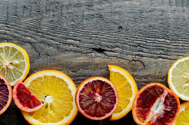 Sliced and cut sicilian blood oranges on wooden natural background, top view Premium Photo
