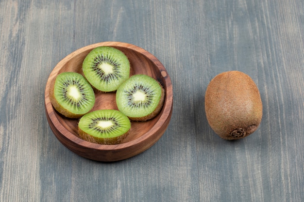 Free Photo Sliced Kiwi With Whole Kiwi On A Wooden Table