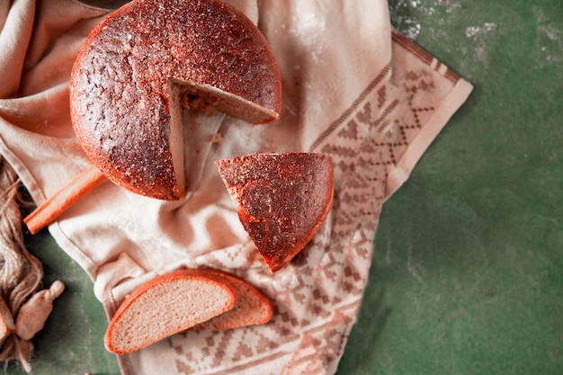 Sliced round traditional bread with herbs on it, top view. Free Photo