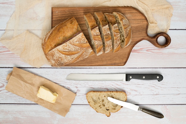 Free Photo Slices Of Bread Knife Butter On Paper And Butterknife On Wooden Table