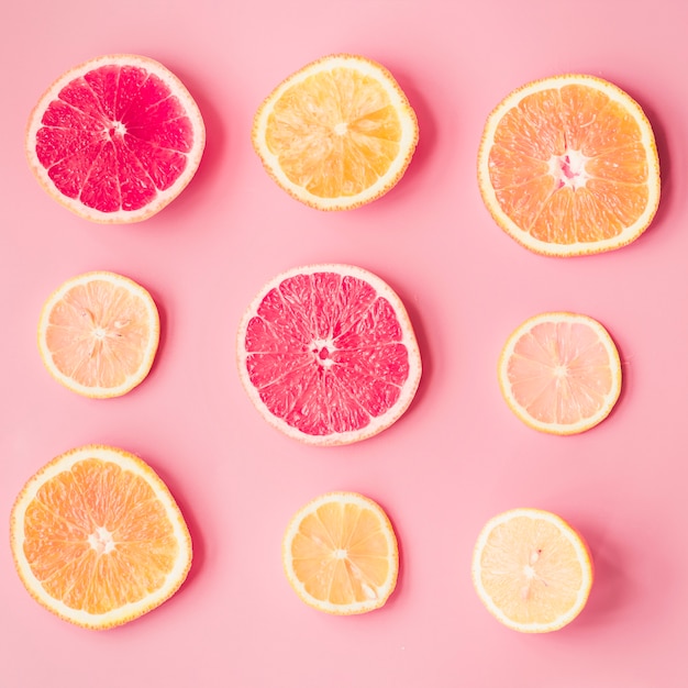 Free Photo | Slices of fresh citrus fruits on pink background