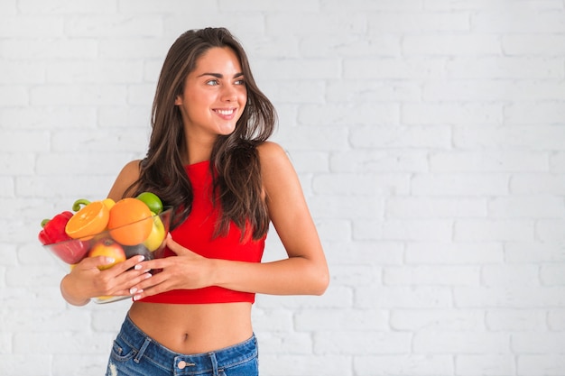 Slim attractive young woman holding healthy fruits and vegetables Free Photo