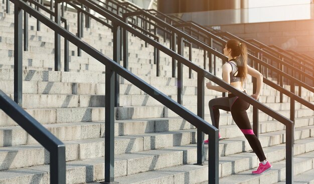 Premium Photo | Slim woman jogging upstairs at sports stadium