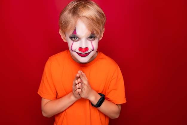 Premium Photo | Sly boy with halloween makeup put his palms together in ...