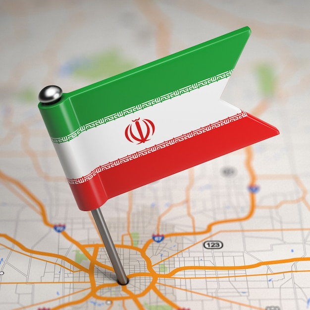  Small flag of islamic republic of iran on a map background with selective focus.
