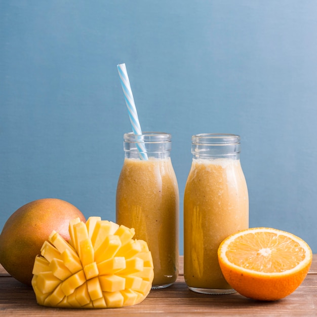 Premium Photo | Small smoothie bottles with mango and orange