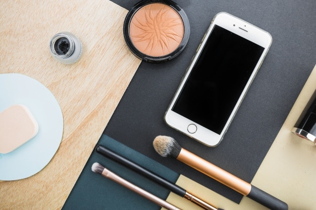 Smartphone near makeup supplies Photo | Free Download