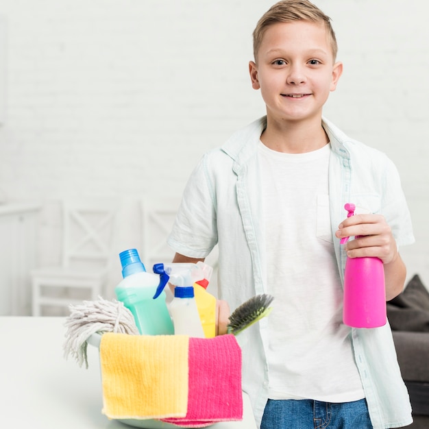 Free Photo | Smiley boy posing with cleaning products