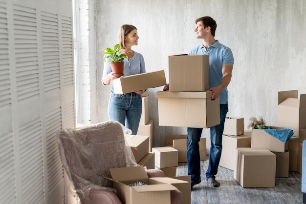 Smiley couple packing together to move house Premium Photo