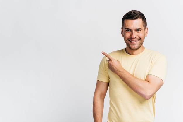 Smiley man pointing with copy space Free Photo
