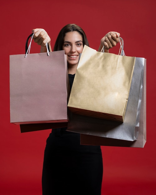 Smiley woman holding up her shopping bags Free Photo