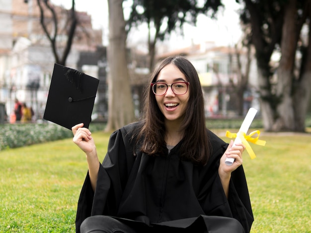 Smiley young woman at graduation ceremony Free Photo