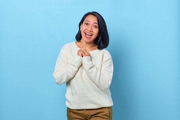 Premium Photo Smiling Asian Woman Holding Hands Together On Blue Background