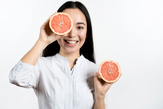 Smiling asian woman making funny face over white background Free Photo