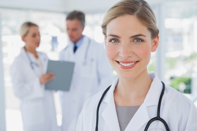 Premium Photo | Smiling blonde haired doctor standing in her office