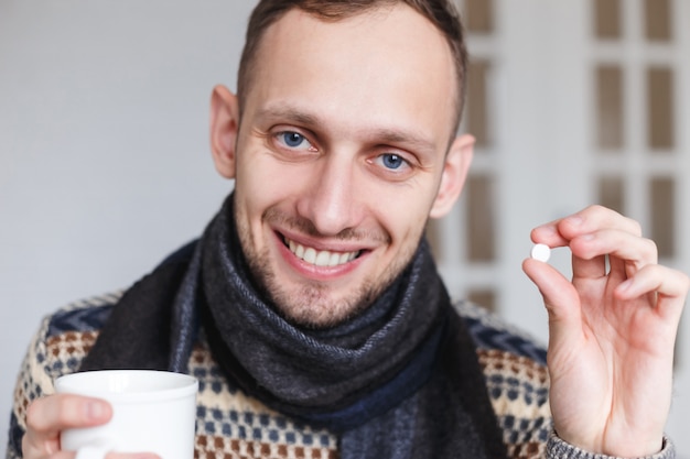 premium-photo-smiling-caught-a-cold-man-shows-pills-for-health-before