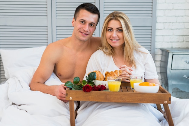 Free Photo Smiling Couple In Bed Near Breakfast On Board