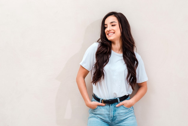 Premium Photo Smiling Cute Girl Wearing A White T Shirt And Jeans Posing Place For Advertising