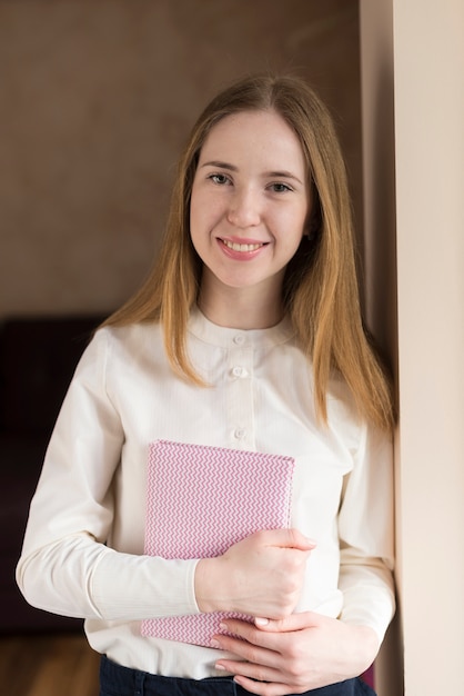 Smiling girl holding a notebook Photo | Free Download