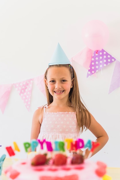 Free Photo | Smiling girl posing behind birthday cake in party